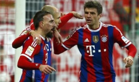 Franck Ribery (kiri), dan Thomas Mueller (kanan) memeluk Arjen Robben setelah pemain Belanda itu mencetak gol ke gawang Freiburg, Rabu (17/12) dini hari WIB.