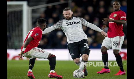 Wayne Rooney (tengah) saat membela Derby County. Rooney resmi pensiun setelah diangkat sebagai pelatih tetap Derby pada Jumat (15/1). 