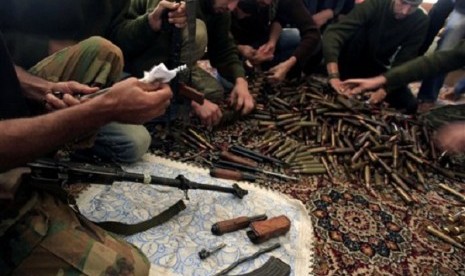 Free Syrian Army fighters clean their weapons and check ammunition at their base on the outskirts of Aleppo, Syria. (file photo) 