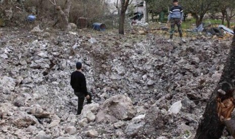 Free Syrian Army fighters inspect a crater caused by what activists said were barrel bombs dropped by government forces at the Jabal al-Akrad area in Syria's northwestern Latakia province January 23, 2014. 