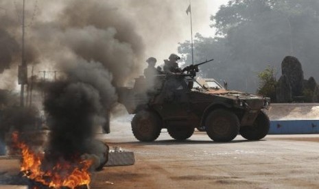 French troops secure an area after protesters from an angry mob set fire to the dead body of a Muslim man along a street in Bangui, January 19, 2014.