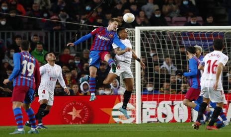 Frenkie de Jong dari Barcelona, kiri tengah, dan Diego Carlos dari Sevilla berebut bola selama pertandingan sepak bola La Liga Spanyol antara FC Barcelona dan Sevilla di stadion Camp Nou di Barcelona, ??Spanyol, Ahad, 3 April 2022.