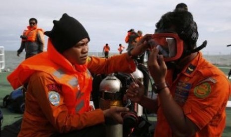 Indonesian divers prepare their gear on the deck of SAR ship Purworejo during a search operation for passengers onboard AirAsia flight QZ8501, in Java Sea, Indonesia on January 2, 2015.