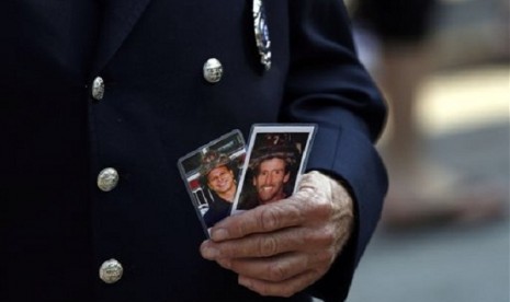 Friends and relatives of the victims of the 9/11 terrorist attacks gather at the National September 11 Memorial at the World Trade Center site, Wednesday, Sept. 11, 2013, for a ceremony marking the 12th anniversary of the attacks in New York. 