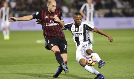 Gabriel Paletta dari AC Milan (kiri) dan Patrice Evra dari Juventus dalam babak pertama final Supercoppa Italiana di Al Sadd Sports Club di Doha, Qatar, Jumat, 23 Desember 2016.