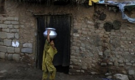 Gadis Pakistan yang mengungsi dari kawasan tribal yang dilanda pertempuran, tengah mengambil air dari sebuah sumur di kawasan kumuh Islamabad.