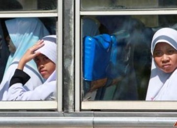 Gadis pelajar Muslim melihat dari bus kota di propinsi Narathiwat, Thailand Selatan.