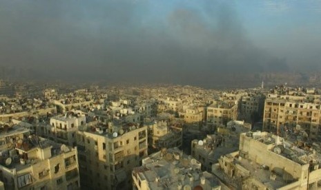 Gambar dari video pada 12 Desember 2016 menunjukkan asap yang membumbung akibat bom di timur Aleppo, Suriah.