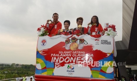 Ganda campuran bulu tangkis peraih medali emas Olimpiade Brasil, Tontowi Ahmad (kedua kanan) dan Liliyana Natsir (kedua kiri) bersama atlet angkat besi Eko Yuli Irawan (kiri) dan Sri Wahyuni Agustiani (kanan) menunjukan medali saat tiba di Terminal 3 baru 