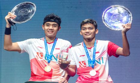 Ganda Putra Indonesia Bagas Maulana (kiri) dan Muhammad Shohibul Fikri mengangkat trofi juara usai laga final nomor ganda putra All England di Utilita Arena Birmingham, Inggris, Minggu (20/3/2022). Bagas/Fikri berhasil menjadi juara All England 2022 setelah mengalahkan ganda putra Indonesia lainnya Muhammad Ahsan - Hendra Setiawan dengan skor 21-19 dan 21-13.