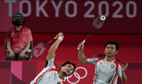 Ganda putra Indonesia Hendra Setiawan (kanan) dan Mohammad Ahsan mengembalikan kok ke arah ganda putra Korea Solgyu Choi dan Seungjae Seo dalam penyisihan Grup D Olimpiade Tokyo 2020 di Musashino Forest Sport Plaza, Tokyo, Jepang, Selasa (27/7/2021). Ahsan dan Hendra berhasil menjadi juara Grup D setelah menang 21-12, 19-21, 21-18 atas Solgyu Choi dan Seungjae Seo.