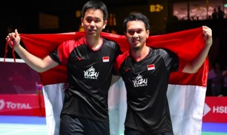 Ganda Putra Indonesia Hendra Setiawan (kiri) dan Mohammad Ahsan membawa bendera Merah Putih seusai memenangi pertandingan melawan ganda putra Jepang Takuro Hoki dan Yugo Kobayashi pada babak final Kejuaraan Dunia Bulu Tangkis 2019 di St. Jakobshalle, Basel, Swiss, Minggu (25/8/2019). Ganda Putra Indonesia menjadi juara dunia setelah menang dengan skor 25-23, 9-21, 21-15 atas ganda Jepang. 