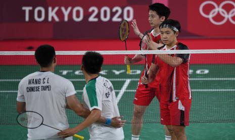 Ganda putra Indonesia Marcus Fernaldi Gideon (kanan) dan Kevin Sanjaya Sukamuljo (kedua kanan) memberikan ucapan selamat kepada ganda putra Taiwan, Yang Lee/Chi-Lin Wang, seusai penyisihan Grup A Olimpiade Tokyo 2020 di Musashino Forest Sport Plaza, Tokyo, Jepang, Selasa (27/7/2021). Marcus dan Kevin kalah 18-21, 21-15, 17-21 dari ganda putra Taiwan.