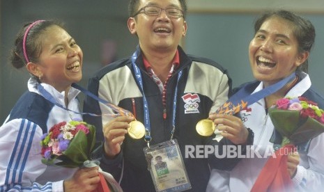 Ganda putri Indonesia Nitya Krishinda (kanan) dan Gresya Polii (kiri) bergembira bersama pelatih mereka Eng Hian (tengah) usai penghargaan medali Asian Games ke-17 di Gyeyang Gymnasium, Incheon, Korsel, 27 September 2014.