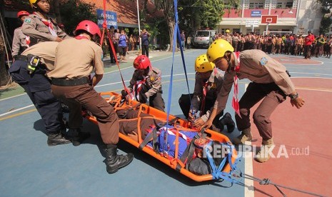 Garda Penolong Pramuka menandu korban gempa saat simulasi tanggap bencana di SDN Kapasari VIII, Surabaya, Jawa Timur, Sabtu (28/4).