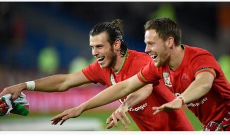 Gareth Bale (kiri) merayakan keberhasilan Wales mengalahkan Andorra bersama rekannya.