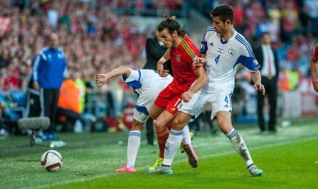 Gareth Bale of Wales ( Centre ) battles to keep the ball in during their UEFA EURO 2016 Group B qualifying round match held at Cardiff City Stadium, Cardiff, Wales, 06 September 2015. 