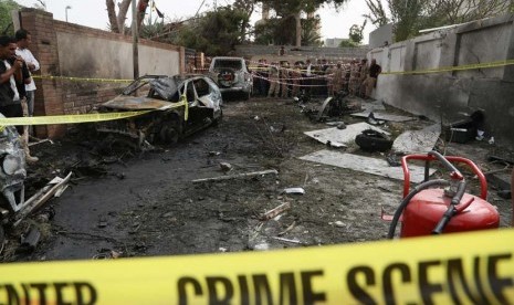  Garis polisi melingkari tempat kejadian ledakan sebuah bom mobil yang menargetkan Kedubes Perancis  di Tripoli, Libya, Selasa (23/4).      (AP/Abdul Majeed Forjani)