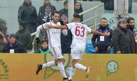 Gelandang AC Milan Hakan Calhanoglu (kiri) merayakan golnya ke gawang Fiorentina bersama rekan setimnya, Patrick Cutrone (kanan) di Stadion Artemio Franchi, Florence, Sabtu (30/12). Milan bermain imbang 1-1 di markas Fiorentina. 