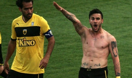 Gelandang AEK Athena Giorgos Katidis memberi salam ala Nazi