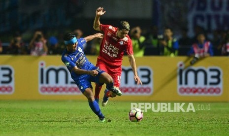 Gelandang  Arema FC, Esteban Vizcarra berebut bola dengan winger Persib Bandung Febri Hariyadi dibayangi dalam pertandingan Gojek Traveloka Liga 1 di Stadion Gelora Bandung Lautan Api, Bandung, Sabtu (15/4). 