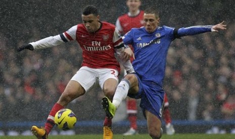 Gelandang Arsenal Francis Coquelin (kanan) berduel dengan striker Chelsea Fernando Torres pada laga Super Sunday di Stamford Bridge, Ahad (20/1) malam.