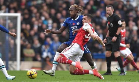 Gelandang Arsenal Granit Xhaka (kanan) berduel dengan pemain Chelsea Trevoh Chalobah saat kedua tim bertemu pada lanjutan Liga Primer Inggris 2022/2023 di Samford Bridge, Ahad (6/11/2022).