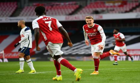 Gelandang Arsenal Martin Odegaard (kanan) berselebrasi usai membobol gawang Tottenham Hotspur dalam laga lanjutan Liga Primer Inggris, Senin (15/3) WIB.