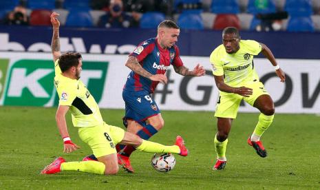 Gelandang Atletico Madrid Saul Niguez (tengah) dijaga dua pemain Levante. Atletico bermain imbang 1-1 kontra Levante.