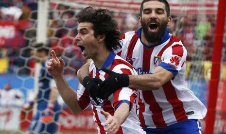 Gelandang Atletico Madrid, Tiago (kiri), berlari meluapkan kegembiraannya usai menjebol gawang Real Madrid dalam laga La Liga Spanyol di Vicente Calderon, Madrid, Sabtu (7/2). 