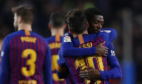 Gelandang Barcelona, Ousmane Dembele (kanan) merayakan gol dengan berpelukan dengan Lionel Messi pada laga Liga lawan Celta Vigo, Ahad (23/12) dini hari WIB.