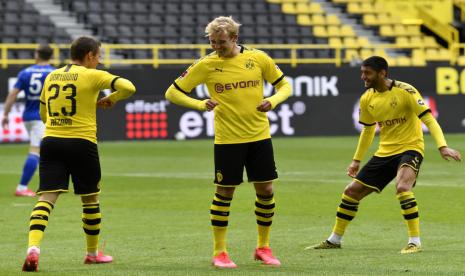 Gelandang Borussia Dortmund Thorgan Hazard (kiri) merayakan golnya bersama Julian Brandt (tengah) pada laga derby Ruhr melawan Schalke 04 dalam lanjutan Bundesliga Jerman di Signal Iduna Park, Dortmund, Sabtu (16/5). Pertandingan ini tanpa penonton dan dengan protokol kesehatan ketat, termasuk perayaan gol yang tak boleh bersentuhan.