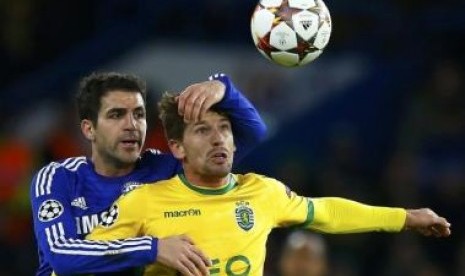 Gelandang Chelsea Cesc Fabregas (kiri) saat berduel bola dengan pemain Sporting Adrien Silva di Liga champions, Kamis (11/12) dini hari WIB.