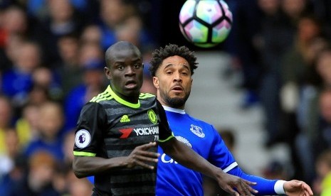 Gelandang Chelsea N'Golo Kante (kiri) berebut bola dengan gelandang Everton Ashley Williams dalam laga Liga Primer Inggris di Goodison Park, Ahad (30/4).