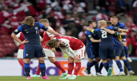 Gelandang Finlandia, Rasmus Schuller (kiri) menenangkan gelandang Denmark, Mathias Jensen yang terlihat kecewa seusai laga kualifikasi Grup B Piala Eropa 2020 di Stadion Parken, Kopenhagen, Ahad (13/6). Finlandia menang 1-0.