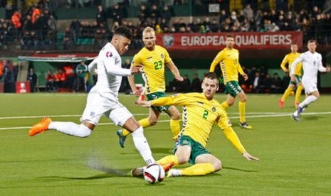 Gelandang Inggris Alex Oxlade Chamberlain yang membawa bola diadang pemain Lithuania Linas Klimavicius.