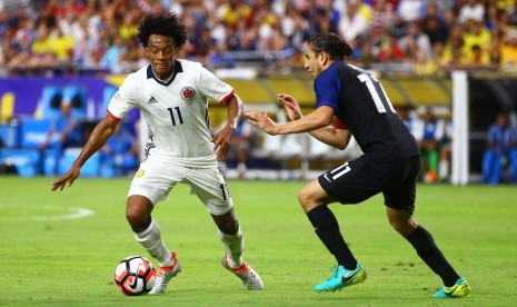 Gelandang Kolombia Juan Cuadrado (kiri) sedang mengontrol bola untuk melewati pemain Amerika Serikat Alejandro Bedoya pada saat kedua tim bertemu untuk memerebutkan tempat ketiga Copa America di University of Phoenix Stadium