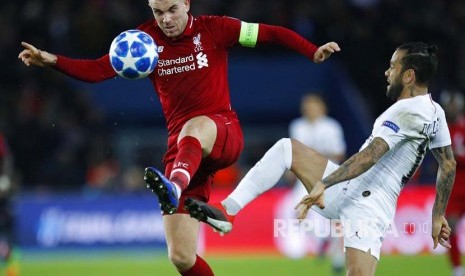 Gelandang Liverpool Jordan Henderson (kiri) berebut bola dengan bek PSG  Dani Alves pada laga Grup C Liga Champions antara Paris Saint Germain melawan Liverpool di stadion Parc des Princes, Paris, Kamis (29/11) dini hari.