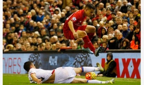 Gelandang Liverpool Philippe Coutinho melompat menghindari tekel pemain Crystal Palace Martin Kelly.