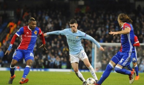 Gelandang Manchester City Phil Foden (tengah) berusaha melewati penjagaan pemain FC Basel.