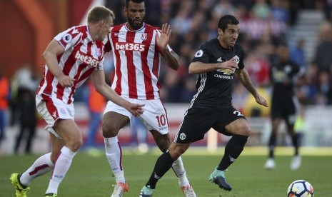 Gelandang Manchester United (MU), Henrikh Mikhtaryan (kanan) menggiring bola dalam penjagaan dua pemain Stoke City pada laga Liga Primer Inggris di Stadium Bet365, Ahad (10/9) dini hari WIB. Laga berakhir imbang 1-1 pada babak pertama.