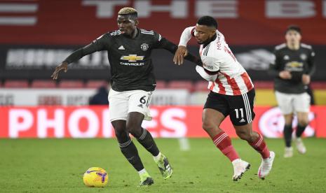 Gelandang Manchester United (MU) Paul Pogba (kiri) dijaga pemain Sheffield United Lys Mouuset dalam pertandingan Liga Primer Inggris di Bramall Lane, Jumat (18/12) dini hari WIB.