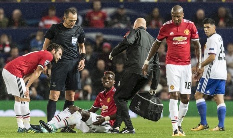 Gelandang Manchester United (MU), Paul Pogba terduduk karena cedera pada laga Liga Champions lawan FC Basel di Old Trafford pekan lalu. Pogba diperkirakan akan cedera panjang.