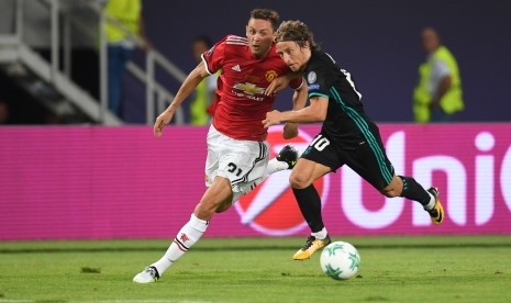 Gelandang Manchester United, Nemanja Matic (kiri) berebut bola dengan gelandang Real Madrid, Luka Modric pada laga Piala Super Eropa di Arena Phillip II, Skopje, Makedonia, Rabu (9/8) dini hari WIB.