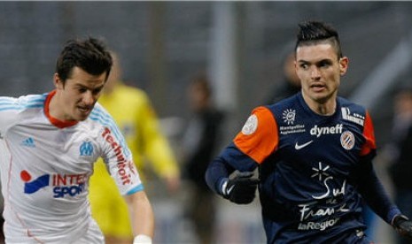 Gelandang Marseille, Joey Barton (kiri), berebut bola dengan gelandang Montpellier, Remy Cabella, dalam laga Ligue 1 Prancis di Marseille. 