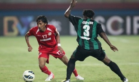 Gelandang Martapura FC Ismail Marzuki (kiri) berusaha melewati adangan bek Persiwa Wamena Robert H Elopere dalam semifinal Divisi Utama Liga Indonesia 2014 di Gelora Delta Sidoarjo, Jatim, Senin (24/11).