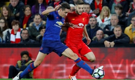 Gelandang MU Ander Herrera (kiri) berusaha menguasai bola meski ditempel ketat pemain Liverpool Adam Lallana.