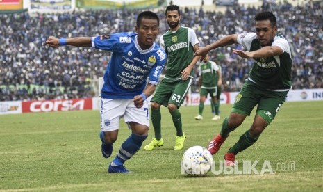 Gelandang Persib Bandung Beckham Putra Nugraha (kiri) berebut bola dengan pesepakbola Persebaya Surabaya saat laga lanjutan Grup A Piala Presiden 2019 di Stadion Si Jalak Harupat, Kabupaten Bandung, Kamis (7/3).