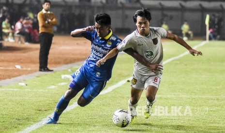 Gelandang Persib Bandung Febri Hariyadi (kiri) berebut bola dengan gelandang Persela Lamongan Kei Hirose (kanan) dalam laga lanjutan Liga 1 2019 di Stadion Si Jalak Harupat, Kabupaten Bandung, Selasa (3/12). 