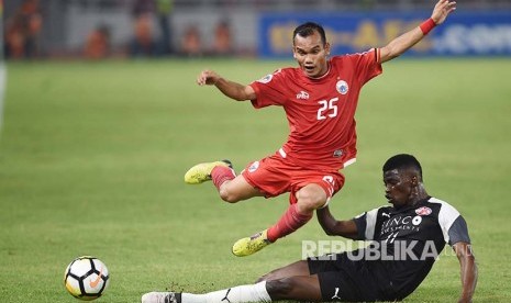 Gelandang Persija Jakarta Riko Simanjuntak (atas) mencoba melewati hadangan pesepak bola Home United Sirina Camara (bawah)